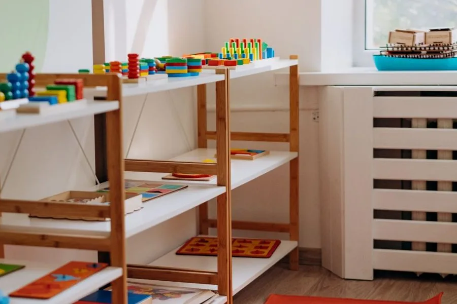 Educational wooden toys on low shelves in a kids' room
