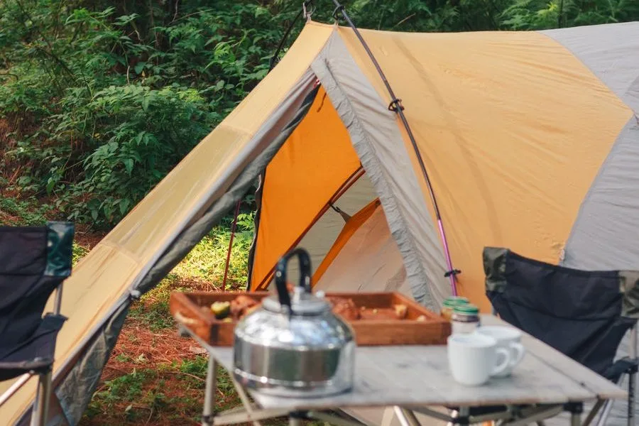 Camp setup with tent and table in a forest