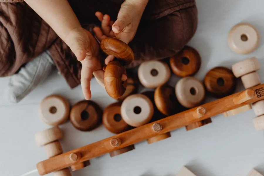 Child's hands playing with wooden toys